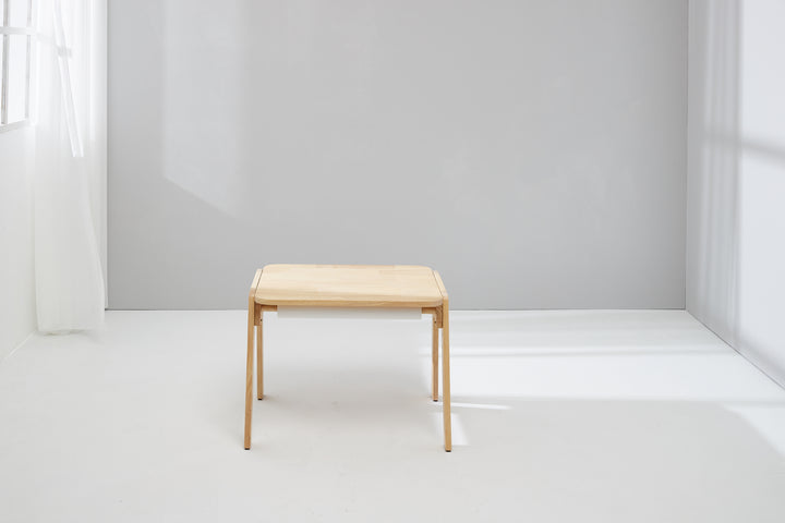 a small wooden table in a white room