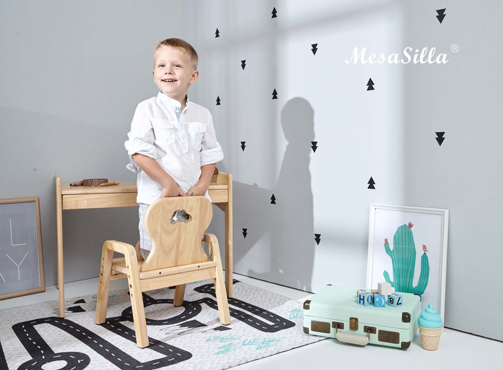 a young boy sitting at a desk in a room