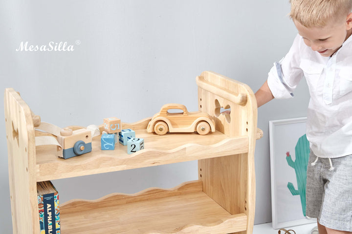 a little boy playing with a wooden toy truck