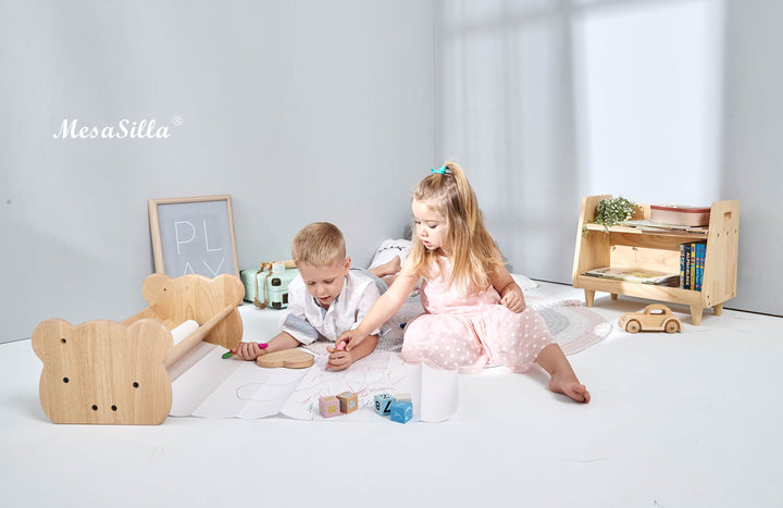 a couple of kids sitting on top of a white floor