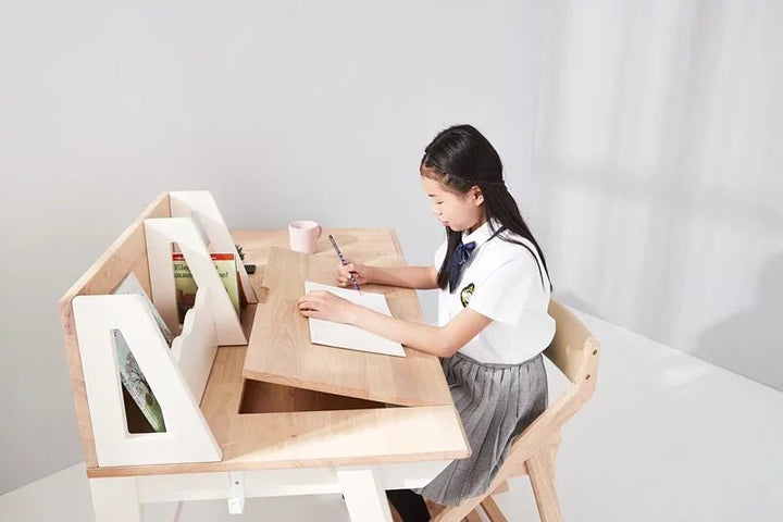 a young girl sitting at a desk writing on a piece of paper