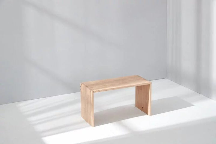 a small wooden bench sitting on top of a white floor