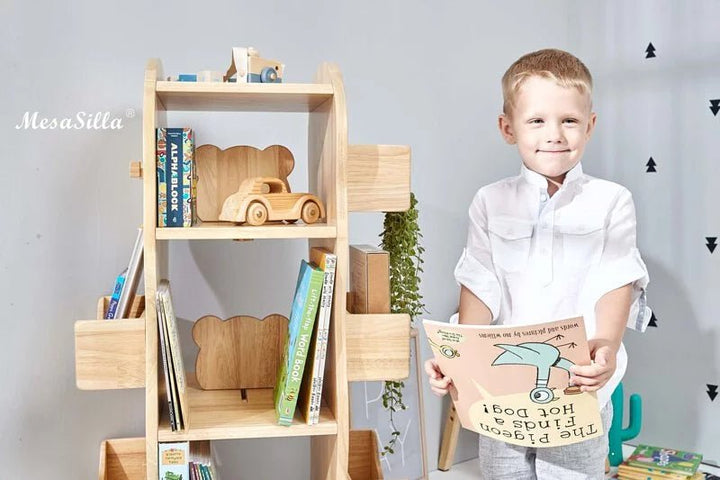 a young boy holding a book in his hands