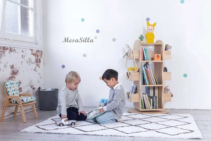 two young boys sitting on a rug in a room