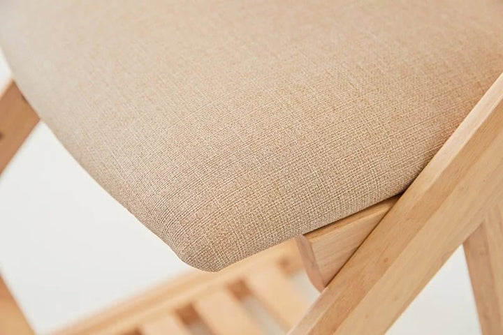 a close up of a wooden chair with a cushion